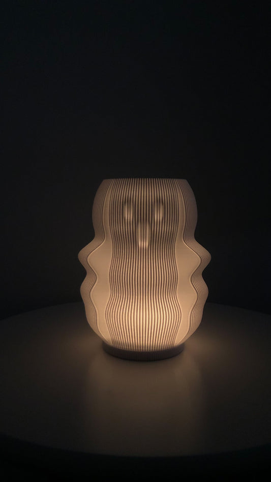Modern decorative lamp with a unique wavy design casting a warm glow in a dark setting