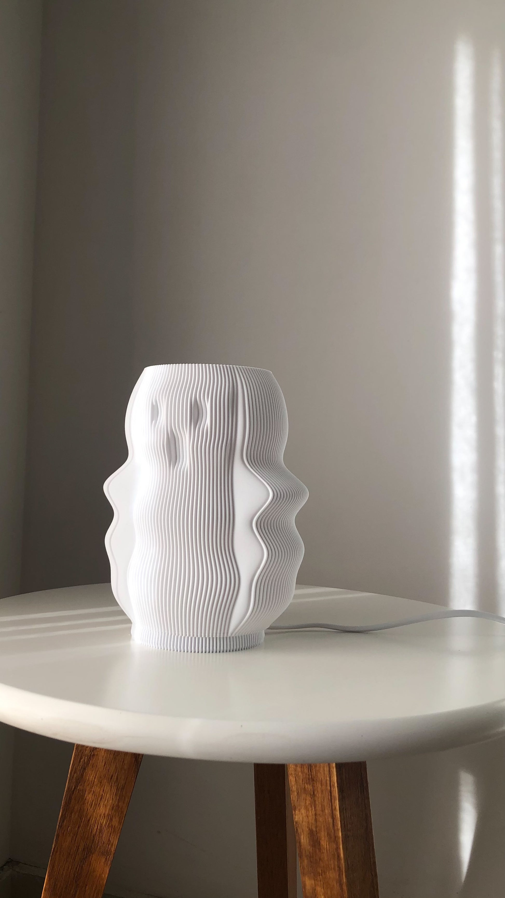Stylish white modern decorative lamp with a unique wavy design on a table