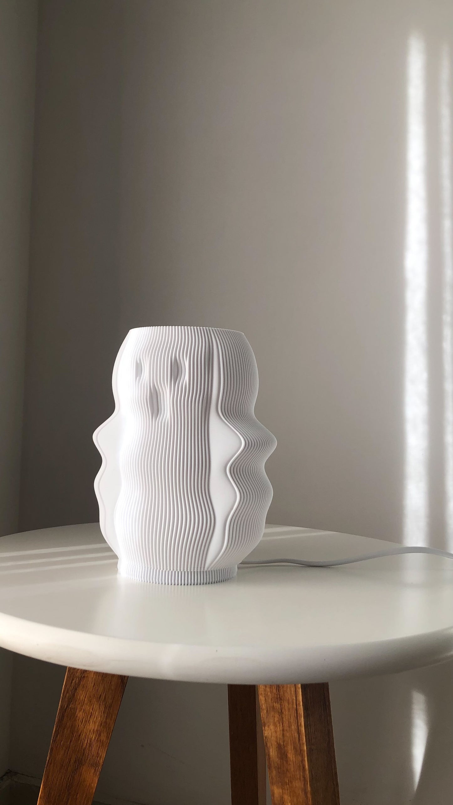 Stylish white modern decorative lamp with a unique wavy design on a table