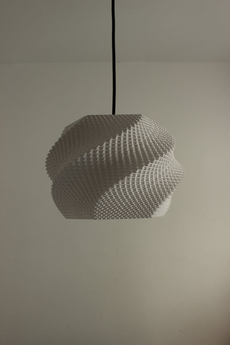 Minimalist textured white pendant shade suspended by a cord over a neutral wall designer ceiling lamp
