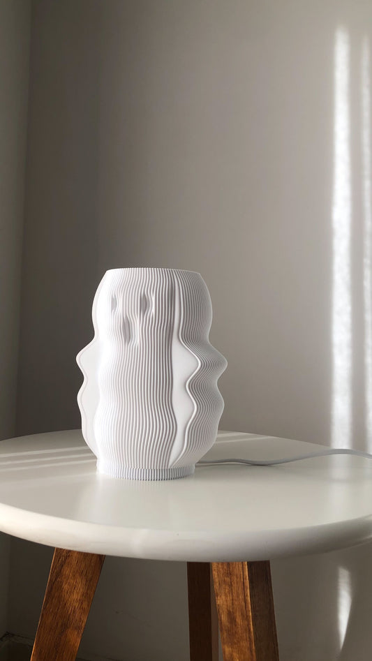 Stylish white modern decorative lamp with a unique wavy design on a table